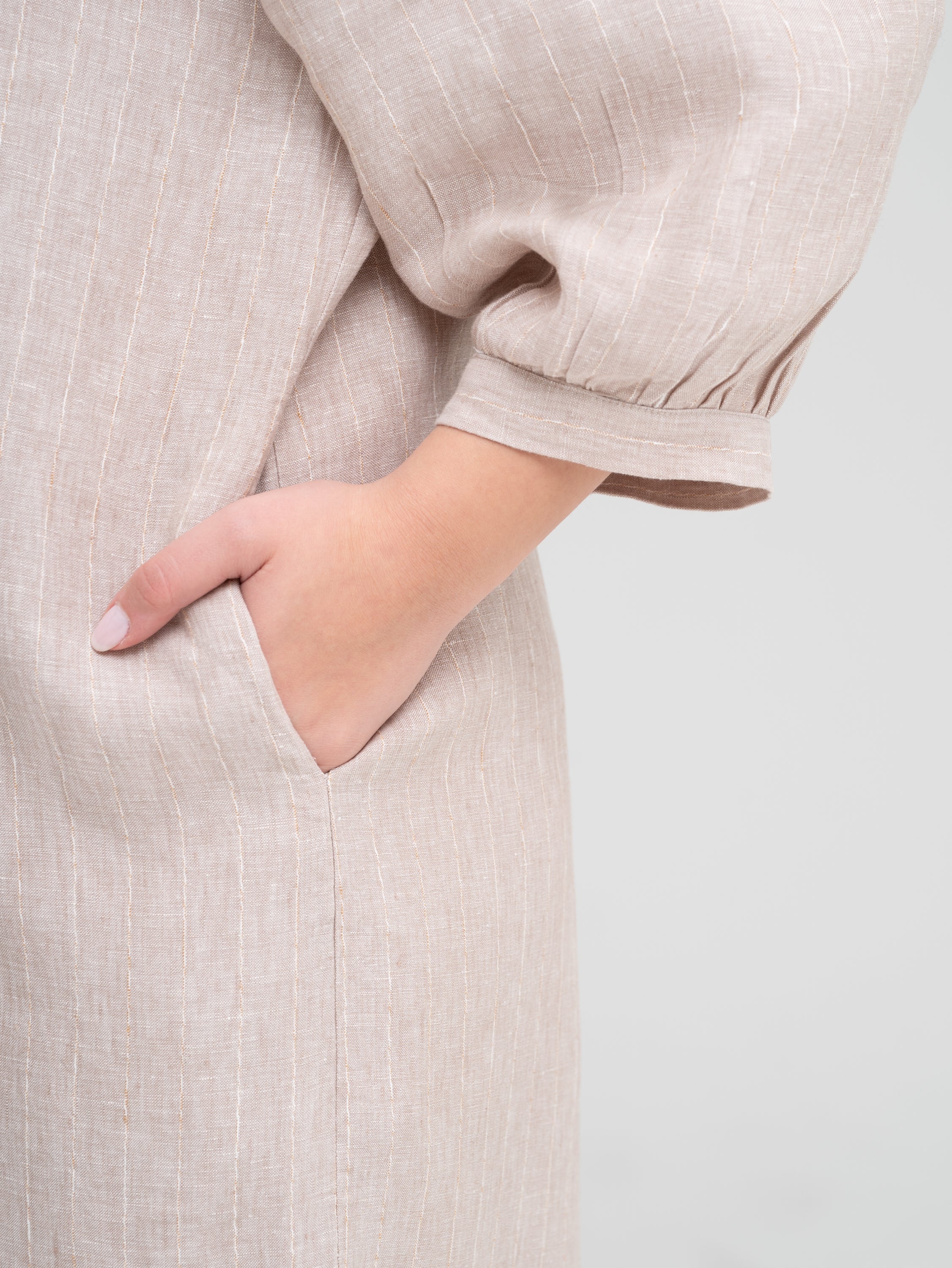 closeup of the pocket detail on a beige puff sleeve shirt dress