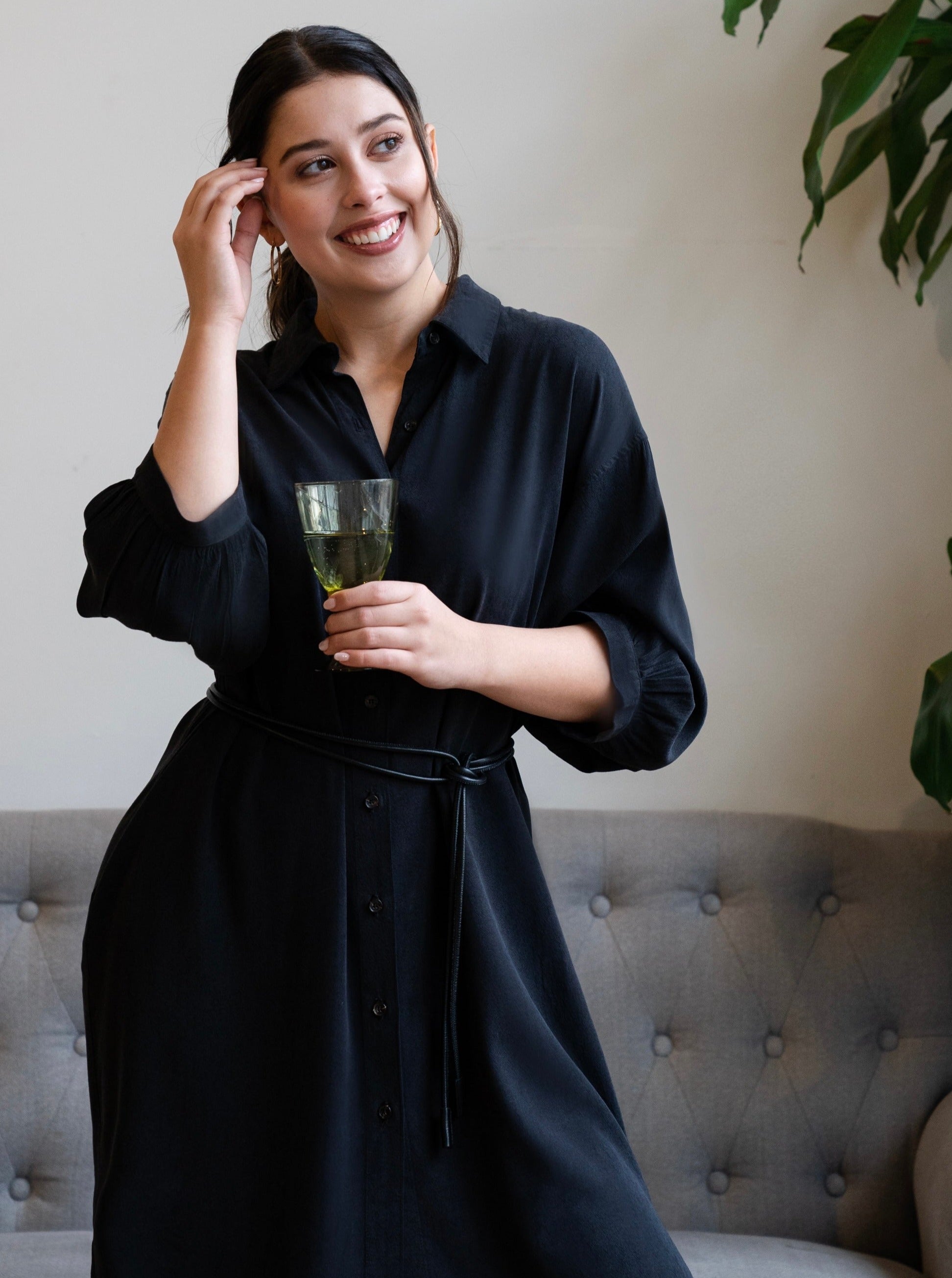 model posing in a black puff sleeve shirt dress