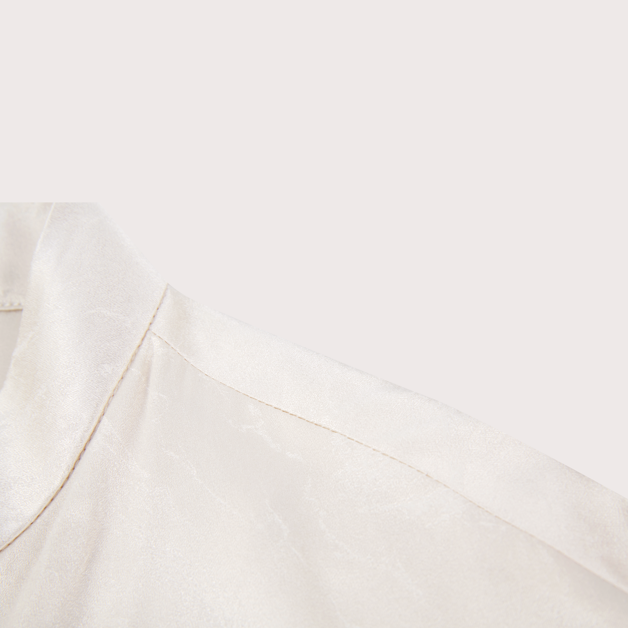 closeup of the shoulder detail on a white silk jacket