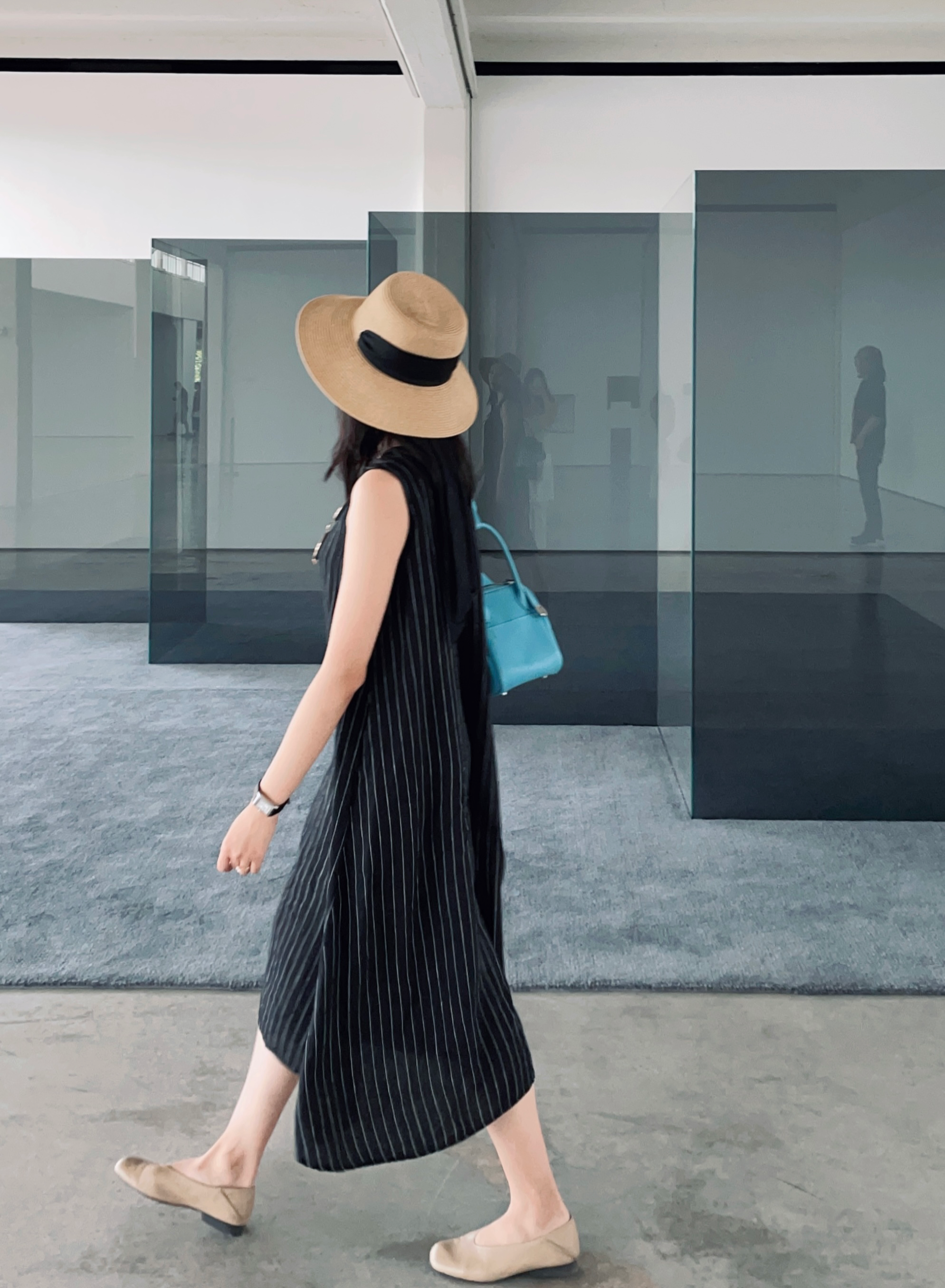 model walking in a black sleeveless midi dress