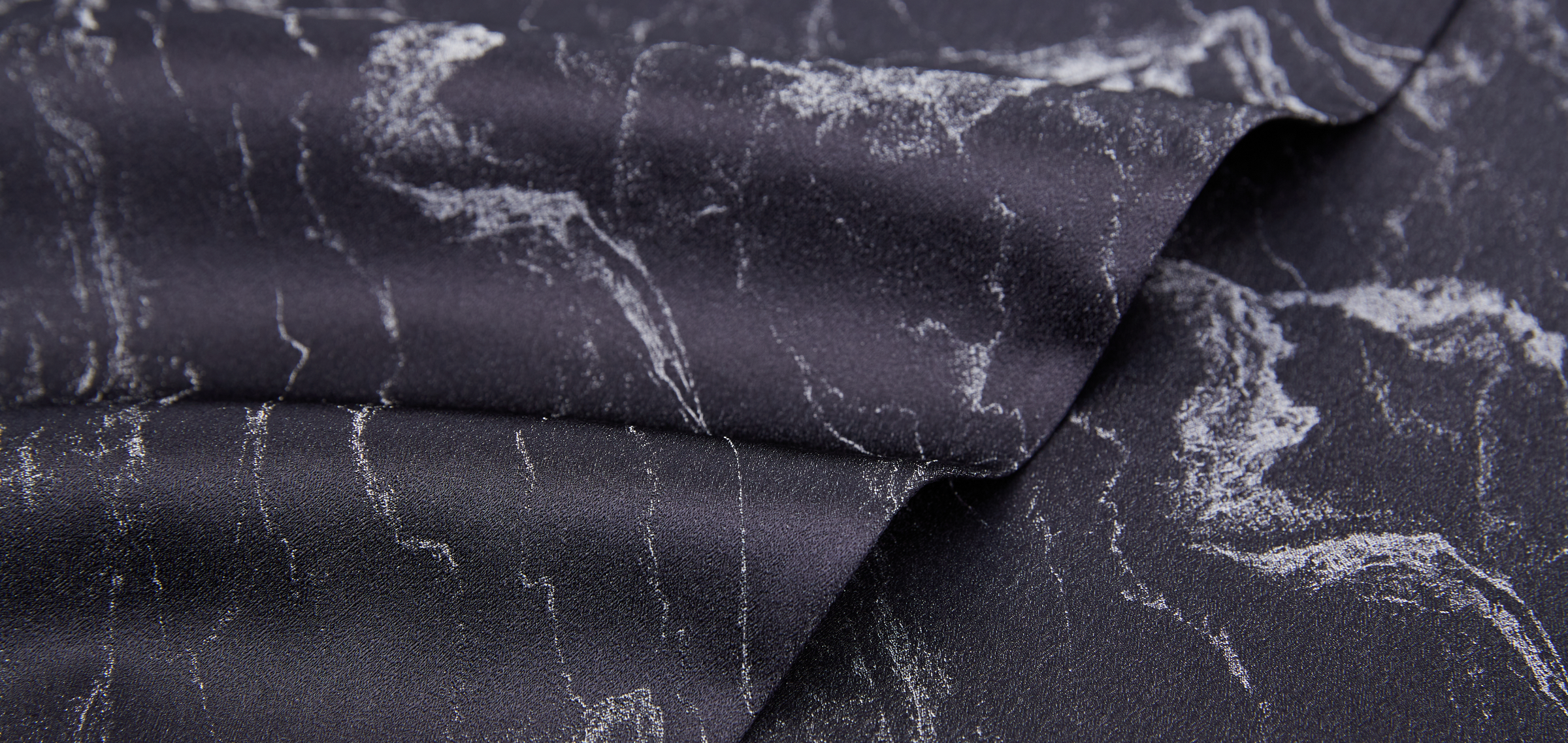 closeup of a printed silk fabric, showcasing intricate patterns and luxurious texture.