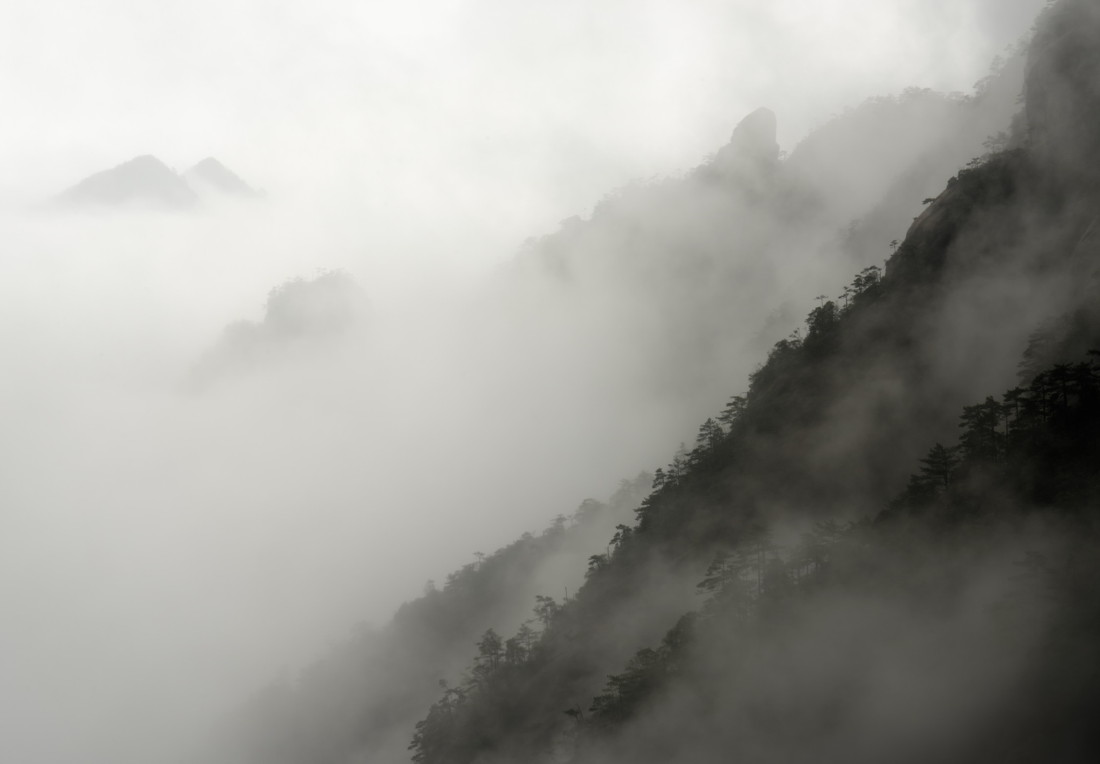 mountains shrouded in mist, creating a serene and atmospheric scene