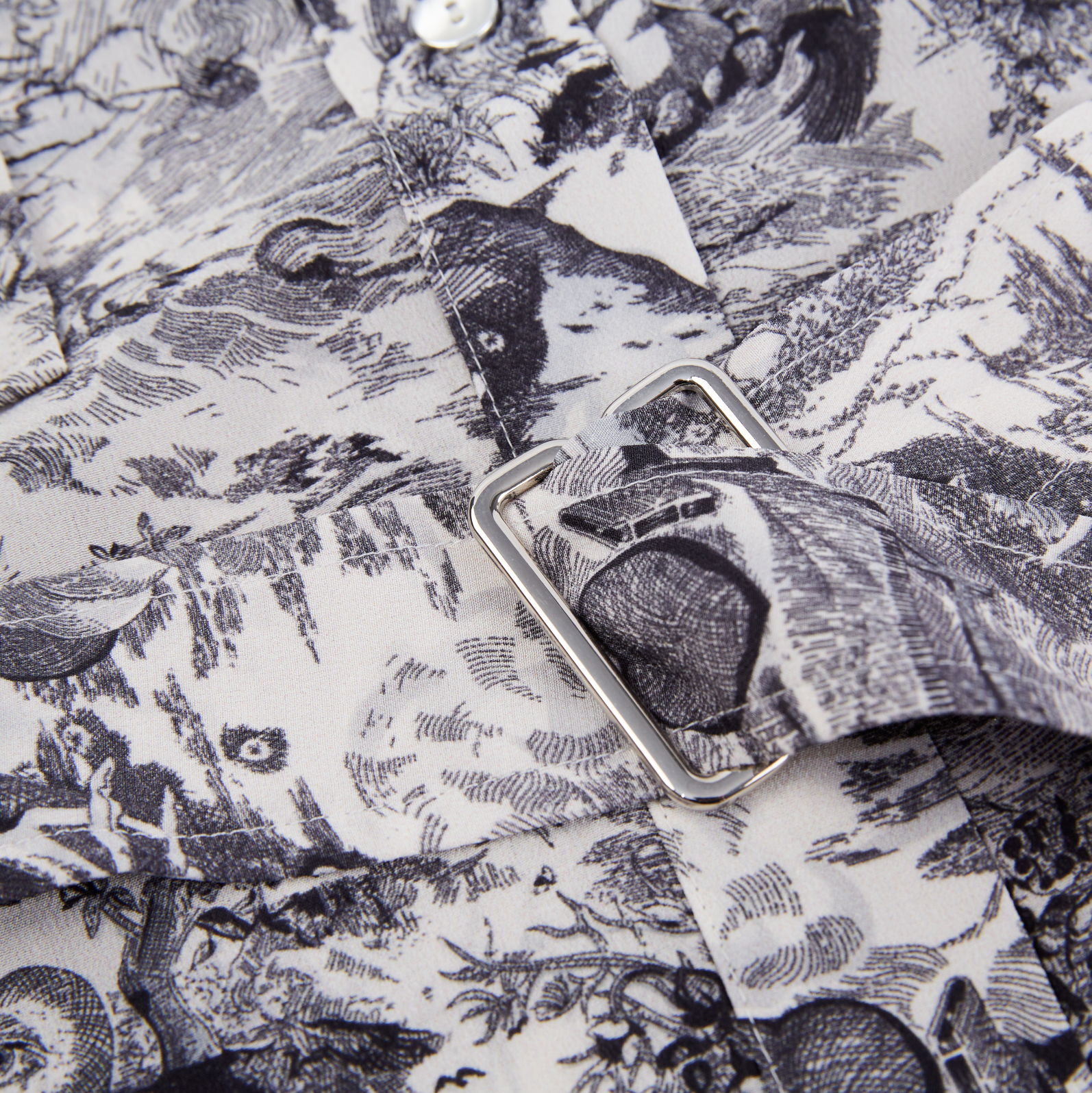 closeup of the belt buckle of a printed silk dress